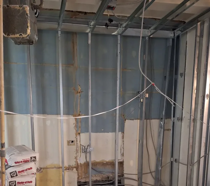 Apartment rewire in Astoria, Queens: new BX cable and boxes run through steel framing by AE Electric